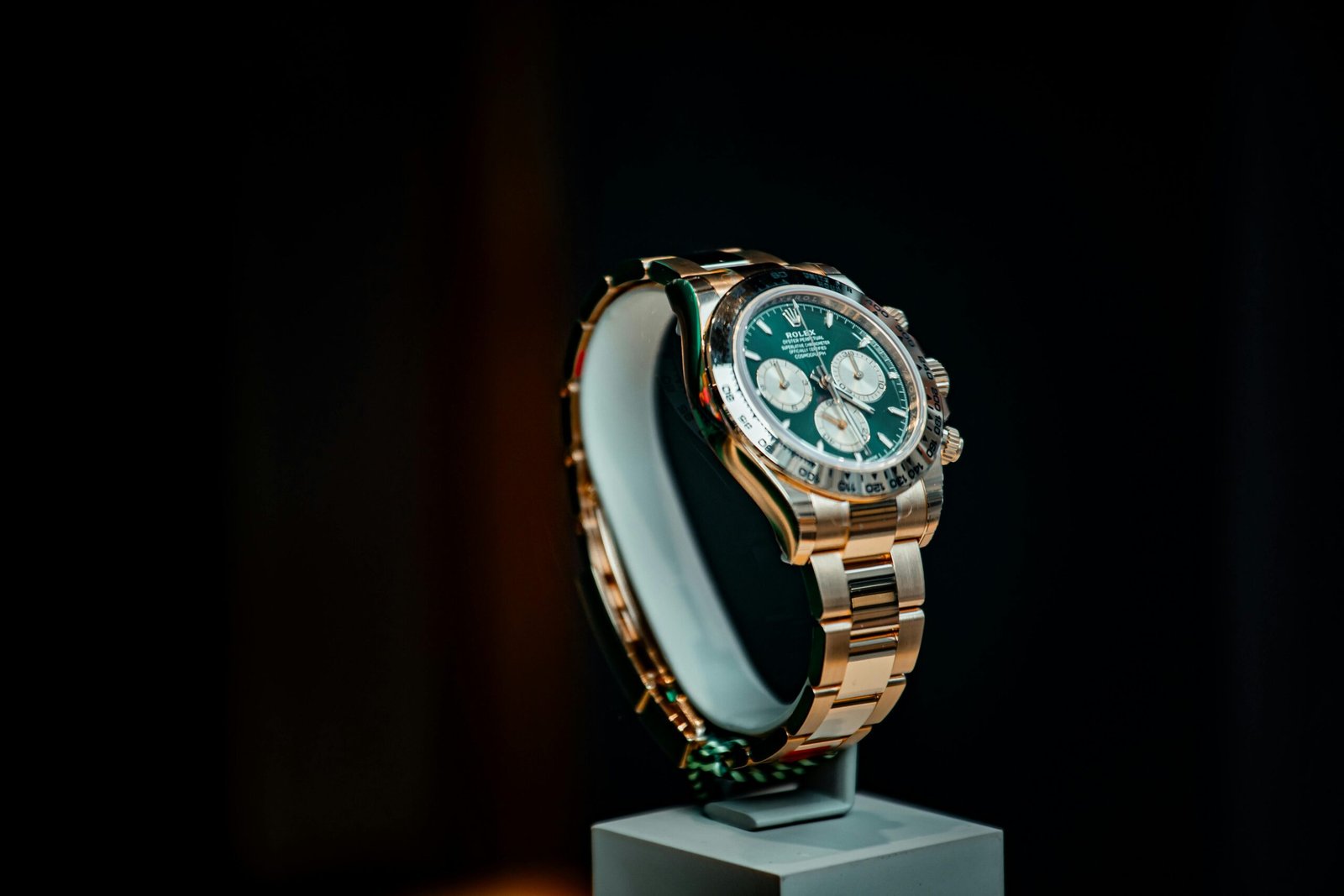 Stunning emerald green and gold luxury watch displayed elegantly against a dark background.